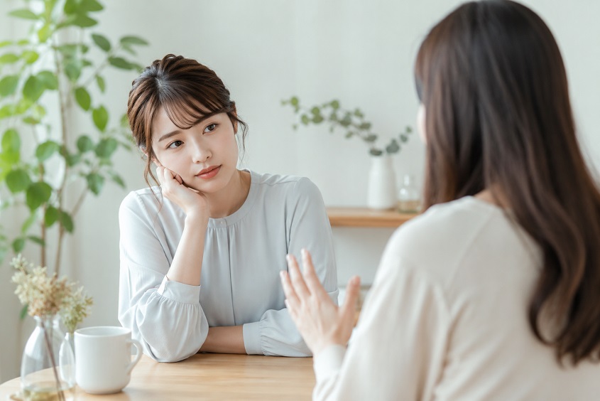 相手の話を聞きながら少し疲れた表情を見せる女性