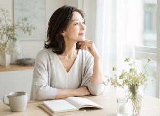 窓辺で自分の気持ちを静かに見つめる40代50代の女性
