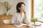 50代からのキャリア再設計をイメージし、窓辺でノートを書きながら静かに自分を見つめる女性
